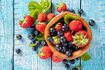 Berry fruit in saucer placed on old wooden planks
