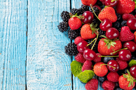 Fresh berry fruit pile placed on old wooden planks