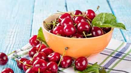 Cherries in basket, placed on old wooden planks