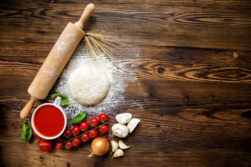 Tuinposter Pizza dough with tomato sauce on wooden table © Jag_cz
