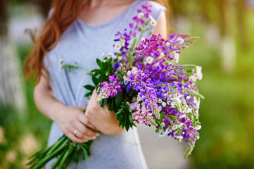 Woman holding a bouquet of blue lupine flowers