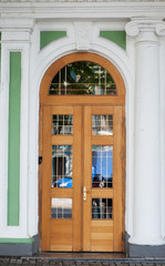 Ornate stained wood doors with wrought iron grating over glass windows