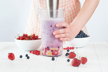 Close up of a female hands blending fruits and berries