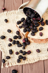 
Summer ripe berries , mulberries in the iron mug on the wooden background 
