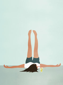 Woman lying on floor with feet up while drinking cold drink