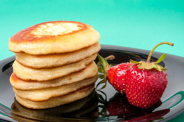 fritters on a plate with strawberries green background