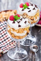 Granola  with cream and fresh raspberries in a glass