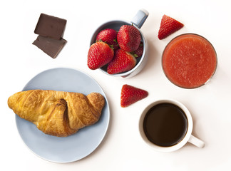 Healthy breakfast: coffee, strawberries,fresh croissant and chocolate pieces