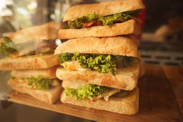 Toned picture of fresh sandwiches closeup with vegetables and meat fish represented in cafe or restaurant.