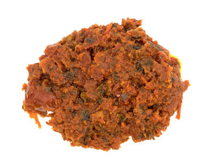Portion of tomato pesto sauce on a white background top view.