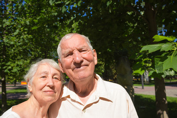 The happy old couple in the summer on a walk