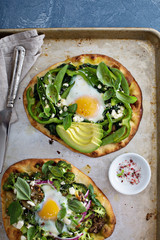 Breakfast pizza with baked egg and greens