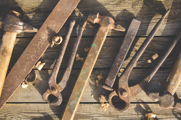 Rusty set of hand tools on a wooden background. Vintage photo