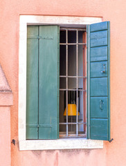 Fototapeta na wymiar Barred window with wooden shutters.