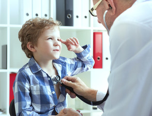Doctor examining a child patient teeth by  orthodontic tools.