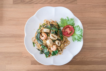 spicy spaghetti seafood on wood table. Thai style