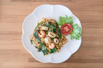 spicy spaghetti seafood on wood table. Thai style
