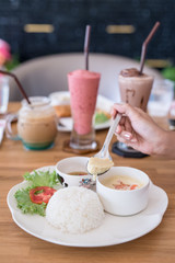 woman eating boiled rice with steamed eggs  on wood table
