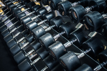 Obraz na płótnie Canvas Dumb bells lined up in a fitness studio. picture is short focus