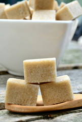 Brown sugar cubes in wooden spoon