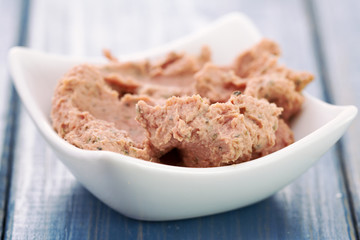 pork pate in bowl on blue woden background