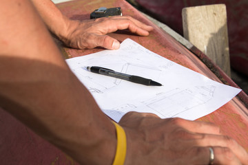 Closeup photo of drawing and carpenter's hands who is going to make design