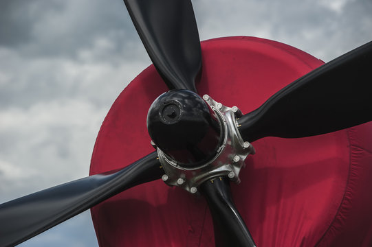 Propeller and engine of old airplane against cloudy sky