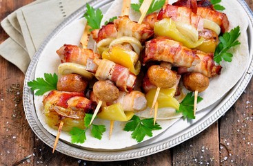 Pork wrapped in bacon on skewers grilled with onions, mushrooms and peppers.