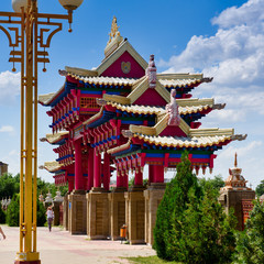 the magnificent gate of the Palace Buddha-red color with carved roofs against bright blue sky