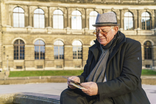 Germany, Dresden, senior man looking at flyers