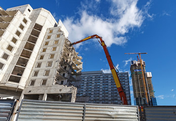 Demolition of a building, machnery working under blue sky