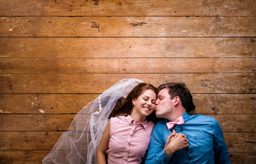 Young couple lying on a floor against wooden background