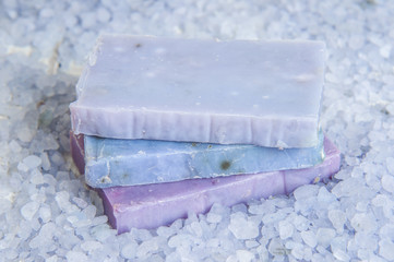 Natural soap, lavender, salt on a wooden board, hygiene items for bath and spa.
