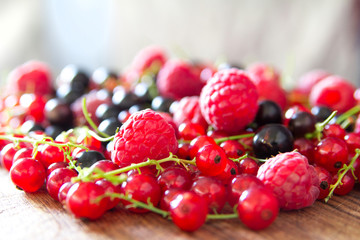 Heap of juicy colorful summer berries. Close up. Modern white kitchen on the background