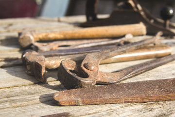 Rusty set of hand tools on a wooden background. Vintage photo