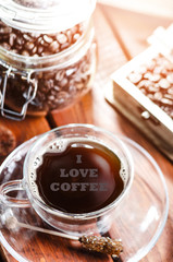 cup of coffee on a wooden backgound. Flowers and grass. Natural background. Agricultural.Garden. I love coffee inscription on a coffee level.