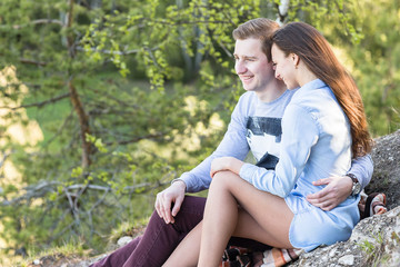 Young couple sitting on the edge of a cliff