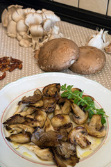 White plate of cooked mushrooms in kitchen