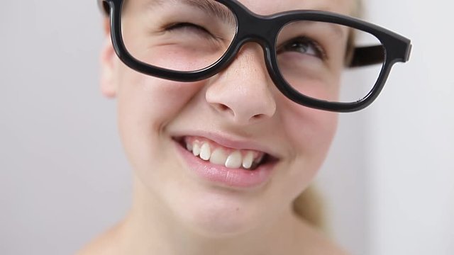 young girl with nerd glasses pointing with the finger to the side