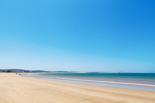 Clear blue sky over emerald sea and yellow sandy beach, Agadir, Morocco