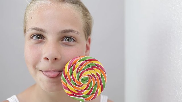 girl holding lollipop and making funny face