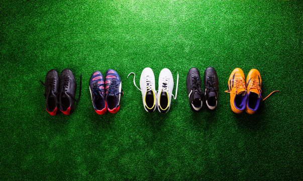 Various cleats against green artificial turf, studio shot