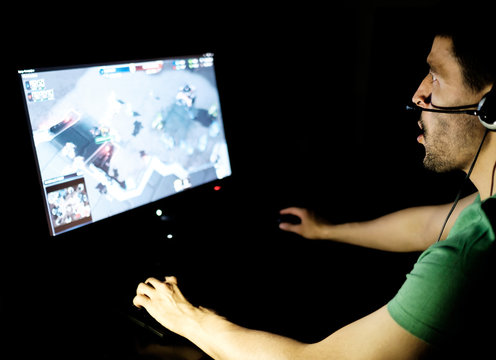 Man playing video game in dark room