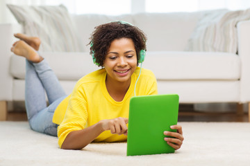 happy african woman with tablet pc and headphones