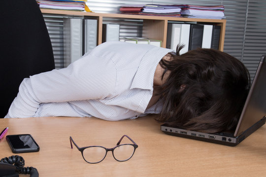 Bored Business Woman With Her Head Lying On The Desk