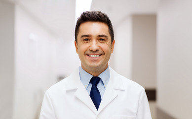 smiling doctor in white coat at hospital