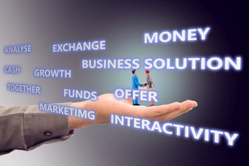 miniature employees handshaking in hand with black background. Image of business concept.