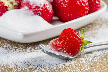 Ripe strawberry in sugar closeup