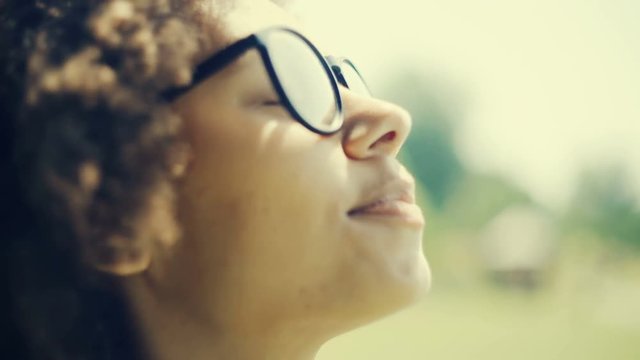 African woman feeling the sun shine on her face