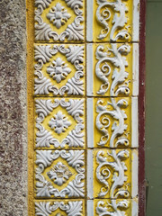 Fototapeta na wymiar A piece of an old yellow floral ceramic tile in Portugal on the